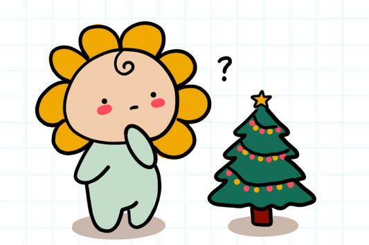 A flower-headed doll stands thoughtfully beside a small Christmas tree decorated with colourful lights and a star on top. The expression suggests doubt or reflection.