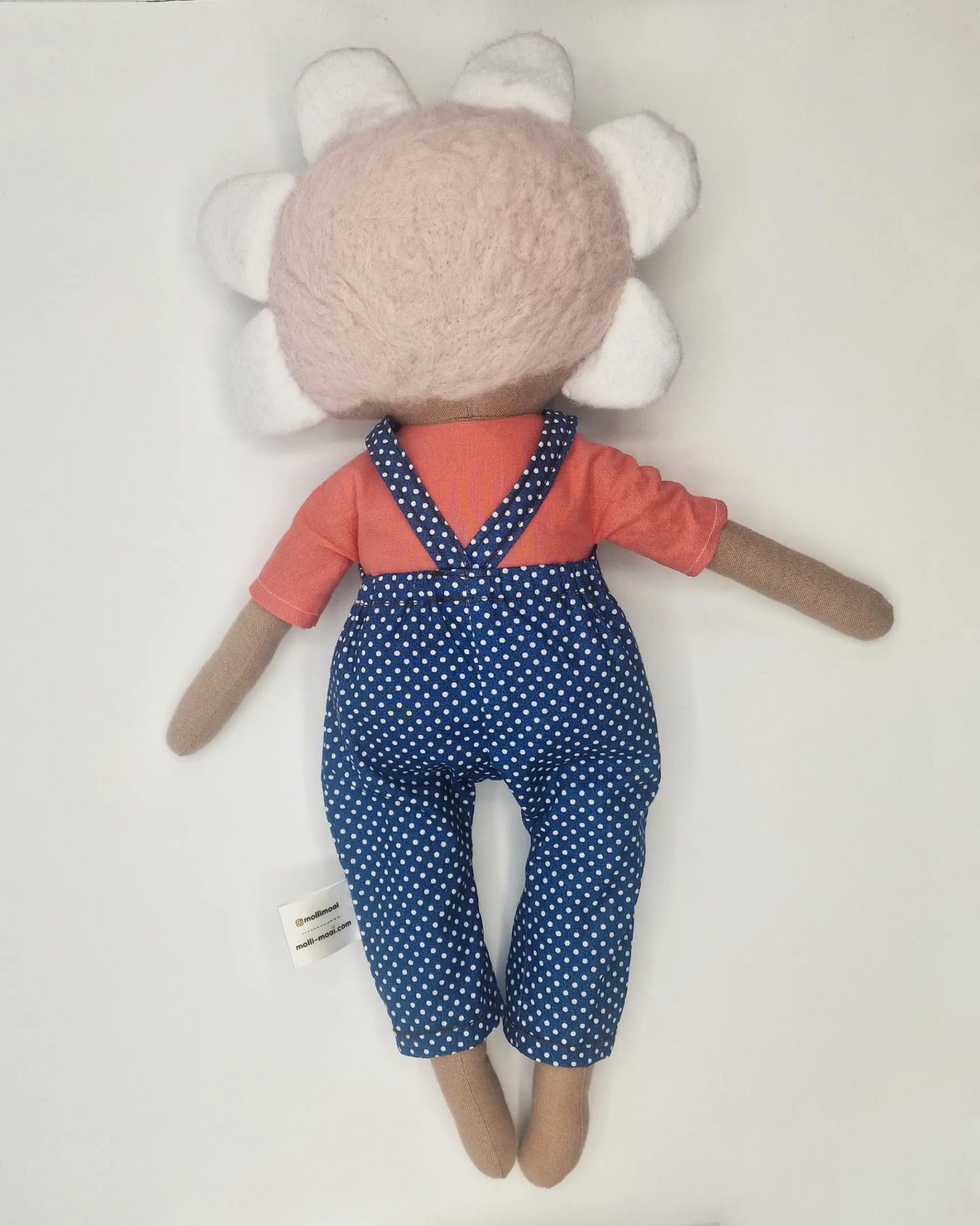 Handmade Daisy doll wearing blue polka dot dungarees and an orange shirt, with apale pink hair and petal-shaped crown.