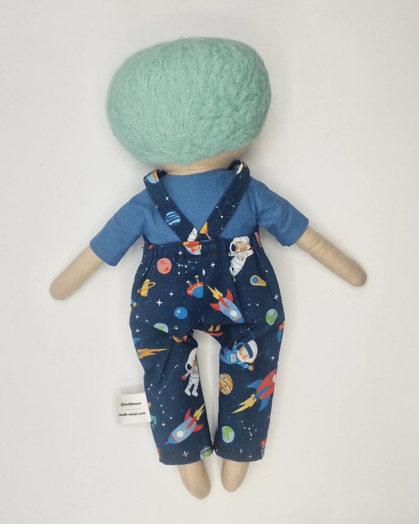 Handmade Daisy doll with light green wool hair, wearing space-themed dungarees and a blue shir.