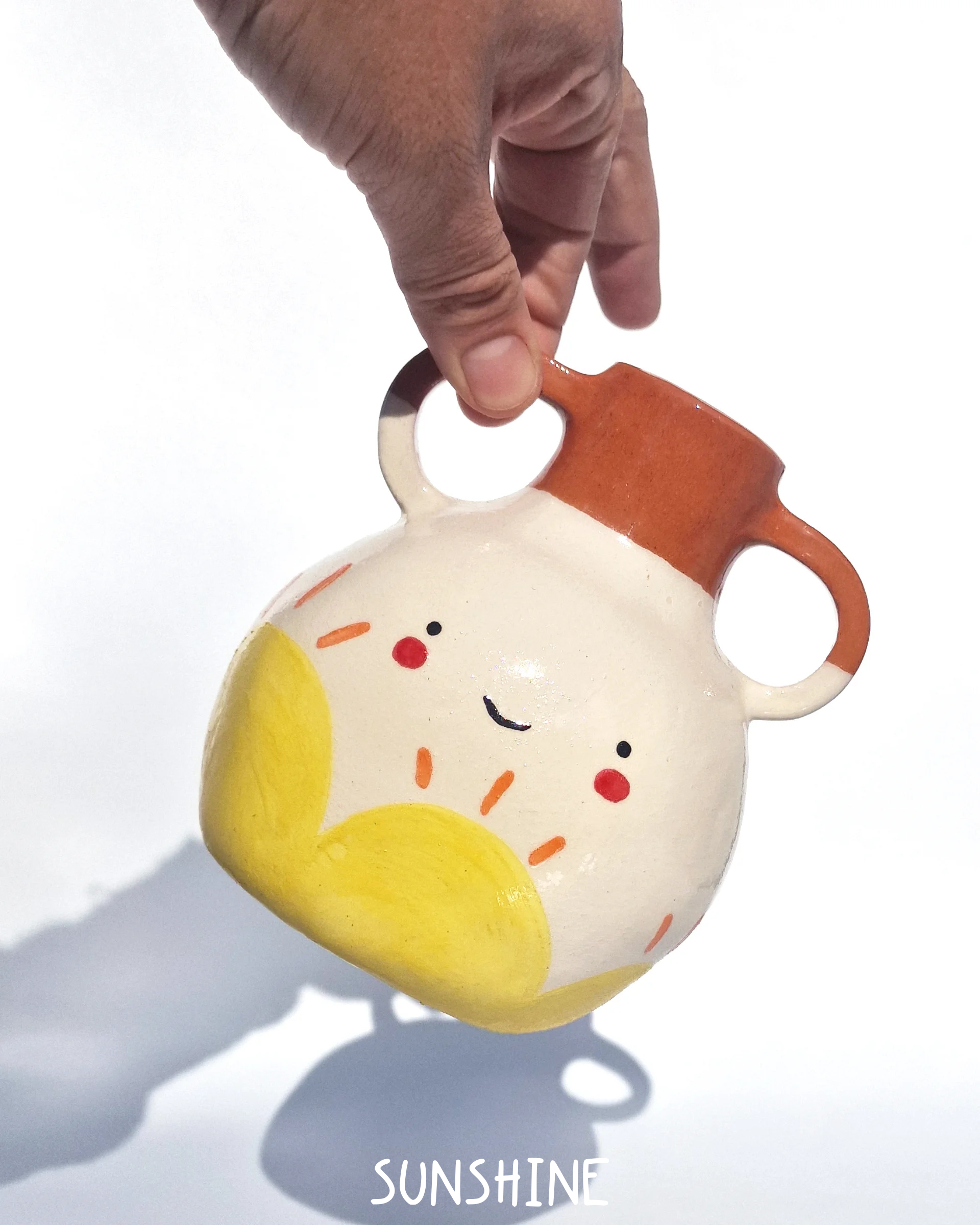 Ceramic jar with a smiley face design on a white background