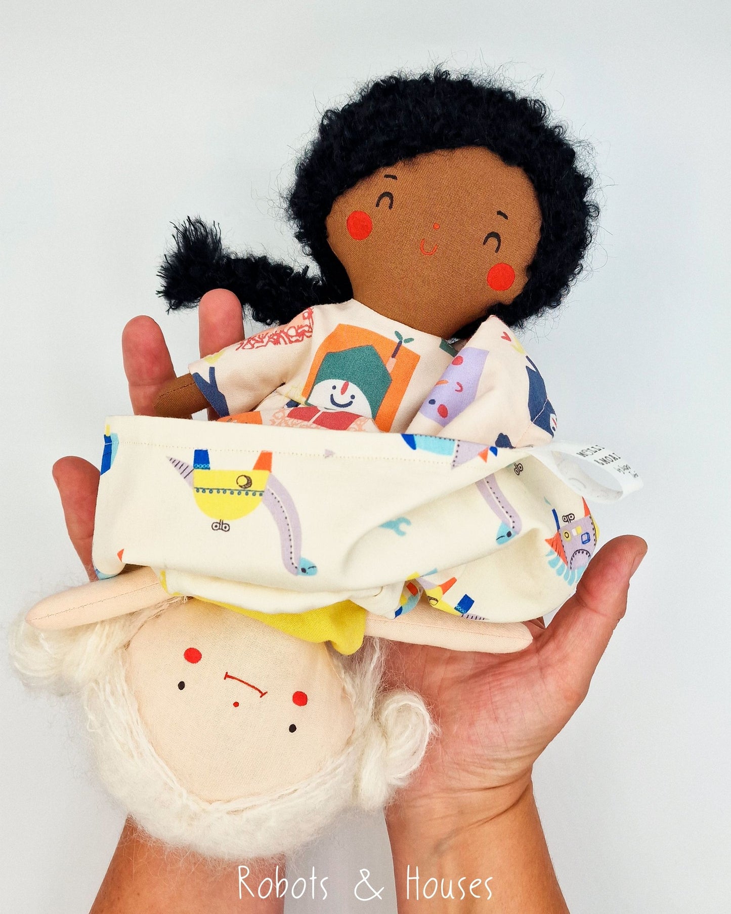 Reversible handmade doll Robots & Houses design shown in hands revealing the two characters